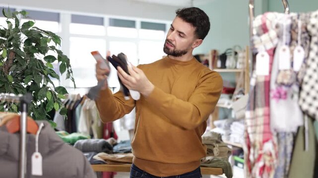 In store, man customer choose socks. Casual practical clothes, natural fabrics. Sales promotion, marketing tricks and discounts. Designer clothes, clothing of world brands 