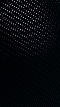 Grid pattern of dark metallic material with blue lighting