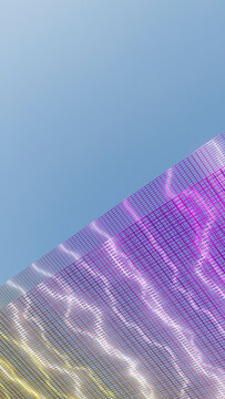Mesh fabric with purple and yellow hues against clear blue sky