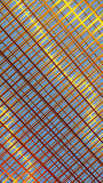 Metallic gold grid structure with intersecting lines against blue sky