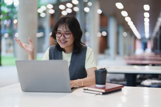 Student enjoying video call on laptop in library