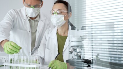 Scientists collaborating on a biotechnology research project in a modern laboratory. Performing...