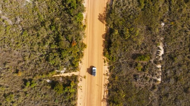 A 4x4 driving on a corrugated road, filmed by a drone