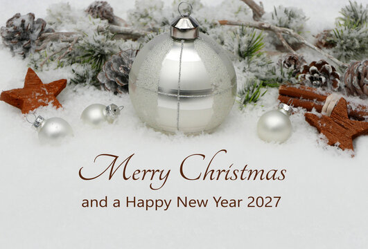  Christmas card featuring silver Christmas ornaments, fir branches, and the words &ldquo;Merry Christmas and a Happy New Year 2027&rdquo; set against a snowy background.