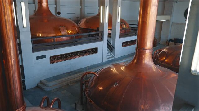 Close view along the curved copper side of a brewing kettle in a historic brewhouse