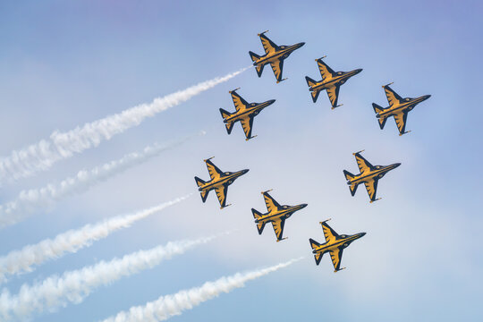Aerial view of Korea Black Eagles aerobatic team flying in a circular formation with smoke trails against a clear blue sky at Changi Exhibition Centre, Singapore, Singapore.