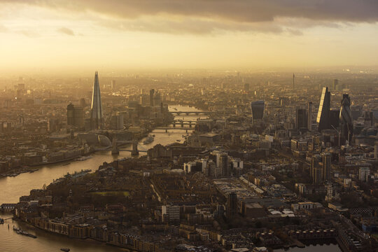 Aerial view of the London skyline at sunset, featuring the Shard, the Gherkin, and Tower Bridge over the River Thames in London, England, United Kingdom.
