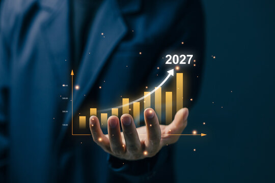 Business professional holding a virtual growth chart marked 2027, representing financial forecasting, business growth, investment strategy, revenue increase, analytics, and future planning.