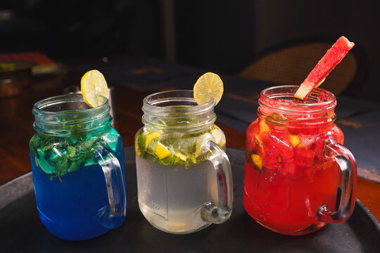 Refreshing and colorful healthy cool drinks served with fresh lemon slices and watermelon garnish. A vibrant summer beverage concept representing freshness, hydration, natural ingredients, healthy lif