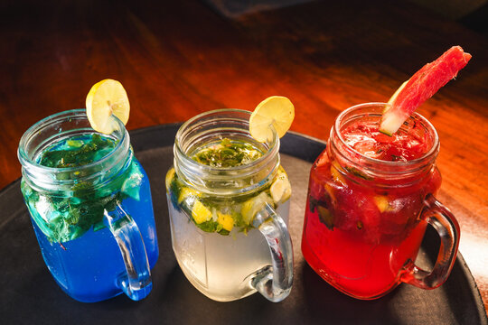 Refreshing and colorful healthy cool drinks served with fresh lemon slices and watermelon garnish. A vibrant summer beverage concept representing freshness, hydration, natural ingredients, healthy lif