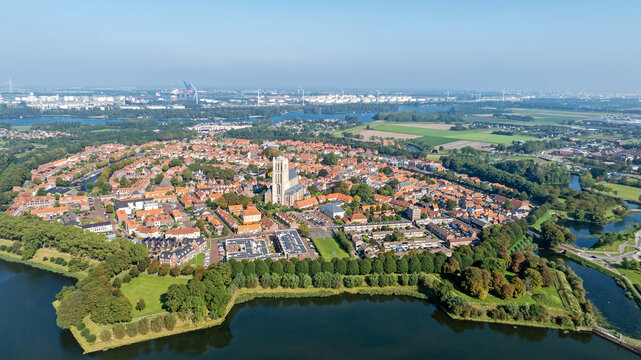 Aerial view of the historic town of Brielle featuring St. Catherine's Church, dense orange-tiled rooftops, defensive moats, and green ramparts in Brielle, South Holland, Netherlands.