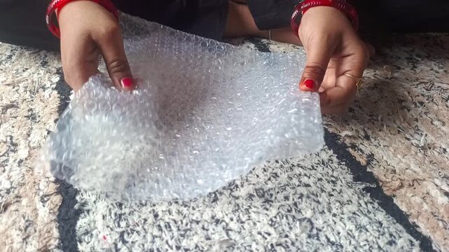 Close up of hands popping plastic bubble wrap packaging material