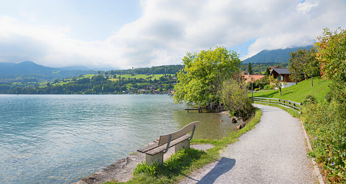idyllic resting place lakeside walkway with bench, tourist resort Faulensee lake Thunersee