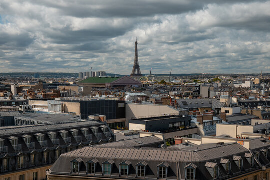 Paris skyline view featuring the iconic eiffel tower dominating the urban landscape, surrounded by traditional haussmann buildings and zinc roofs