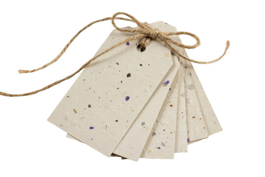 Stack of rectangular recycled paper gift tags with speckled texture and tied with natural brown twine string isolated on a transparent background
