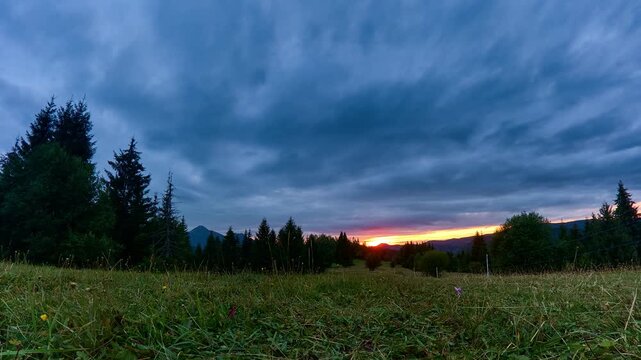 Time Lapse Of Sunset Sky Over Mountain Meadow And Forest Silhouette
