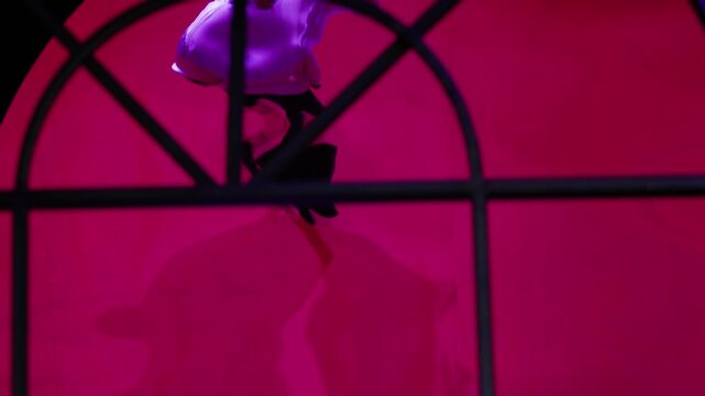 Marionette puppet descending on a magenta stage