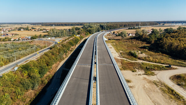 Aerial view of Racha Bridge spanning the landscape with a modern highway, metal guardrails, and surrounding rural fields in Sremska Raca, Vojvodina, Serbia.