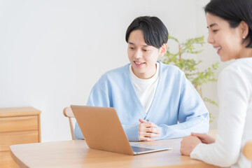 Obraz premium パソコンを見て会話する夫婦・カップル