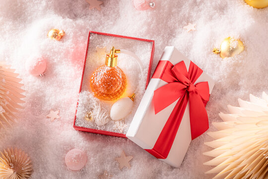 Sweet perfume is poured inside very stylish glass Christmas bottle.