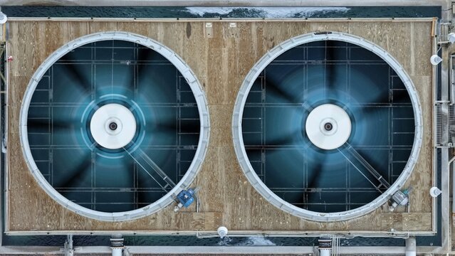 Aerial view of two large industrial cooling fans in operation on a rooftop in Englewood, Colorado, United States.