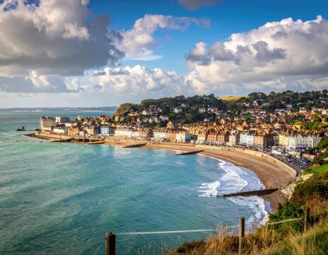 Picturesque coastal town with colorful buildings lining a sandy beach under a dramatic sky.