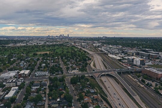 Aerial view of Englewood featuring a highway interchange, railway tracks, and residential neighborhoods with the Denver skyline in the distance, Englewood, Colorado, United States.