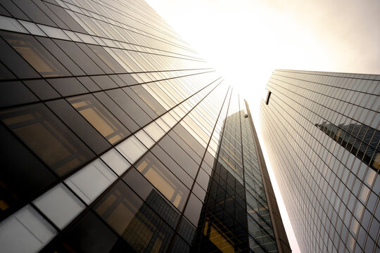 Looking up at glass office towers in La Defense district of Paris France showing contemporary business architecture and bright sunlight