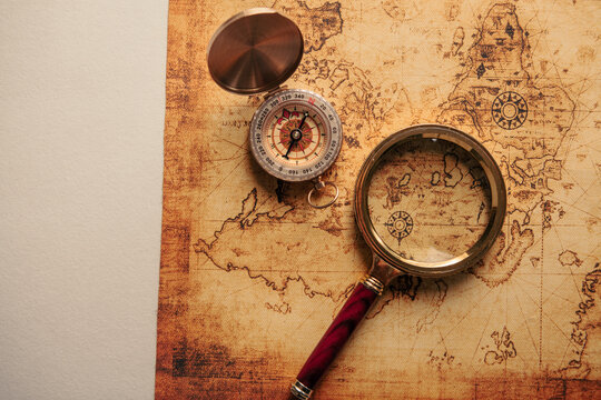 Magnifying glass and old map on wooden background. Vintage style.