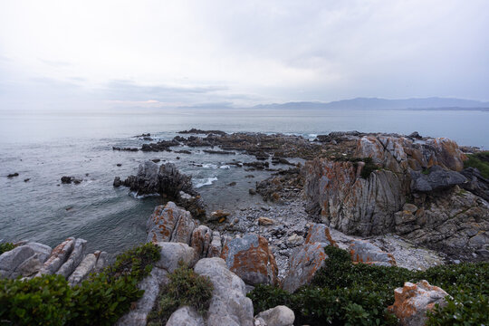 stormy late afternoon light on rocky coastline of DeKelders, South Africa