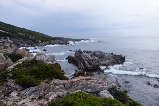 stormy late afternoon light on rocky coastline of DeKelders, South Africa
