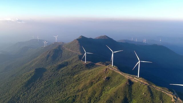 rows of wind turbines on green mountain peaks