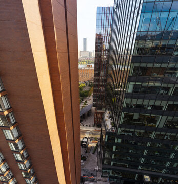 Aerial view of modern glass skyscrapers and brick buildings in an urban setting with a narrow street corridor and distant skyline in Cambridge, Massachusetts, United States.
