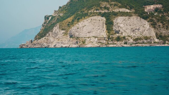 Pale limestone cliff face rising straight out of deep blue water Amalfi coast