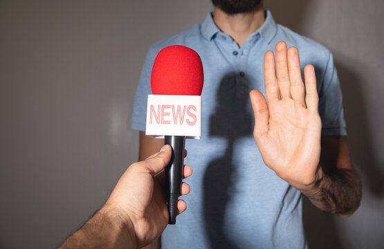 Journalist holding a microphone taking interview.