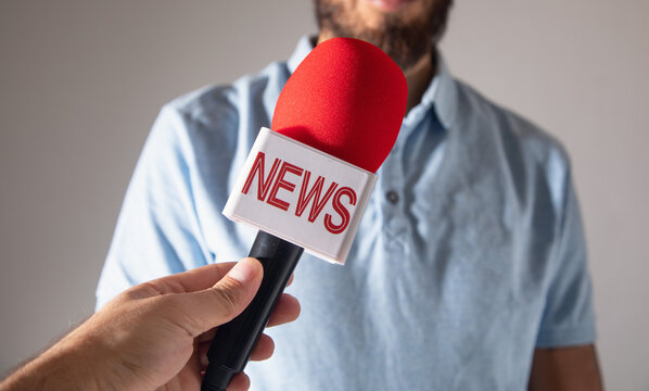 Journalist holding a microphone taking interview.