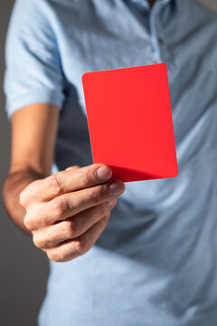 Male hand showing red card.