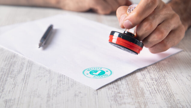 Man holding a stamp on document.