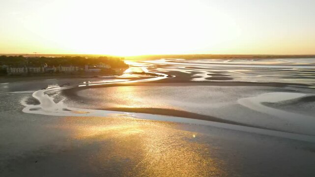 Drone footage of golden sunset over scenic tidal estuary and beach near Howth, Ireland
