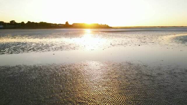 Drone footage of sandy beach with ripple textures at sunset in Howth, Ireland