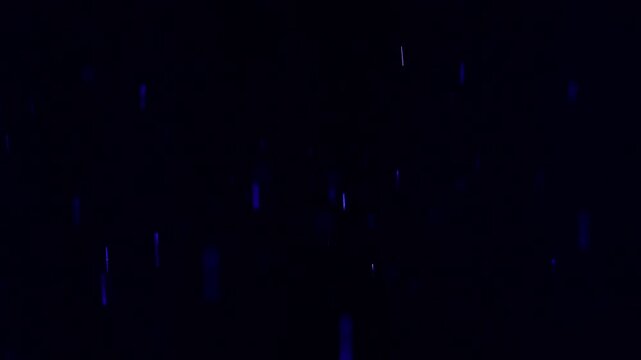 Tiny snow or dust randomly flying in the smoky air, empty space template for objects advertisement. Many dust particles cloud of white powder in blue light on empty dark black contrast background.