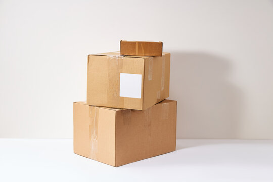 Stack of cardboard boxes with blank label for shipping and delivery on white background