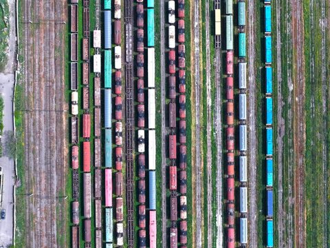 Aerial view of multiple freight trains parked on parallel tracks in a railway yard in Tbilisi, Georgia.