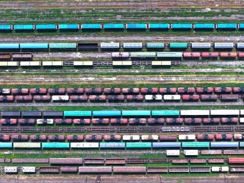 Aerial view of a busy railway yard with numerous colorful freight trains and cargo cars parked on parallel tracks in Tbilisi, Tbilisi, Georgia.