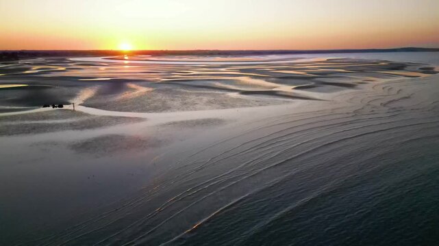 Cinematic aerial shot of beautiful sunset reflections on tidal flats near Howth, Ireland