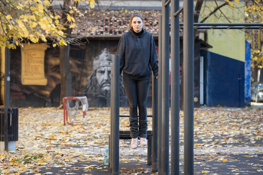 Woman exercising calisthenics on parallel bars in park