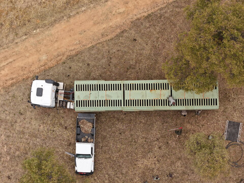 Aerial view of a game capture truck and support vehicle parked in the savanna with ground team members preparing for a wildlife management operation in Thabazimbi, Limpopo, South Africa.