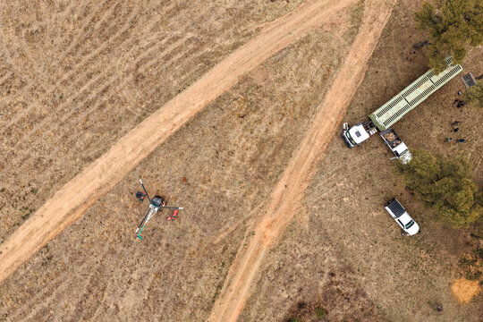 Aerial view of a helicopter, a game capture truck, and a ground team preparing for a wildlife management operation in the dry savanna in Thabazimbi, Limpopo, South Africa.