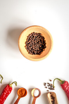 spices in wooden spoon on white background top view