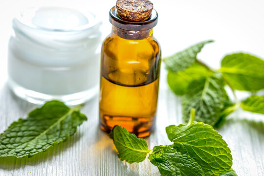 organic cosmetics with herbal extracts of mint on wooden background